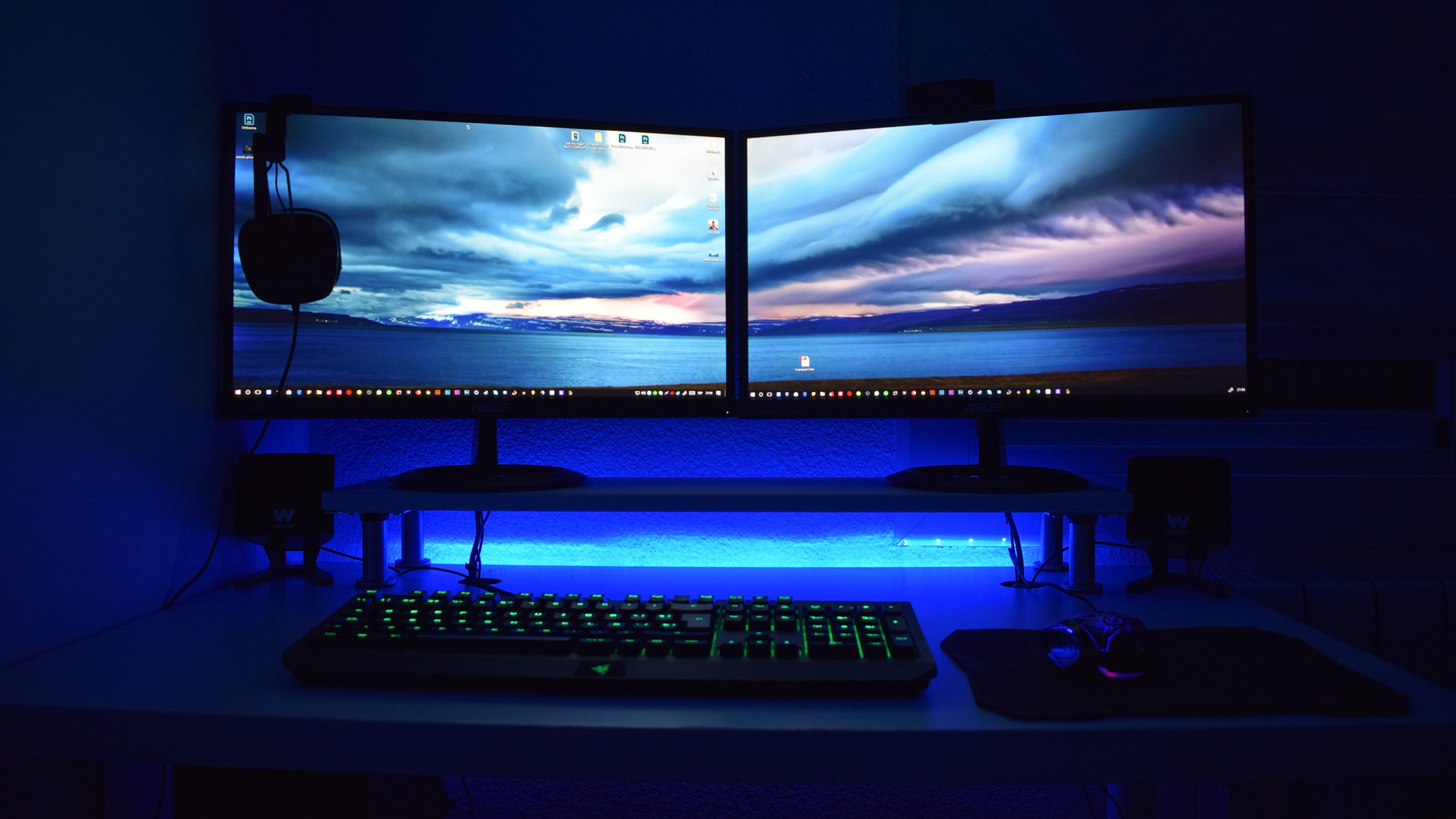 Un bureau avec deux moniteurs, un clavier, une souris et un casque.