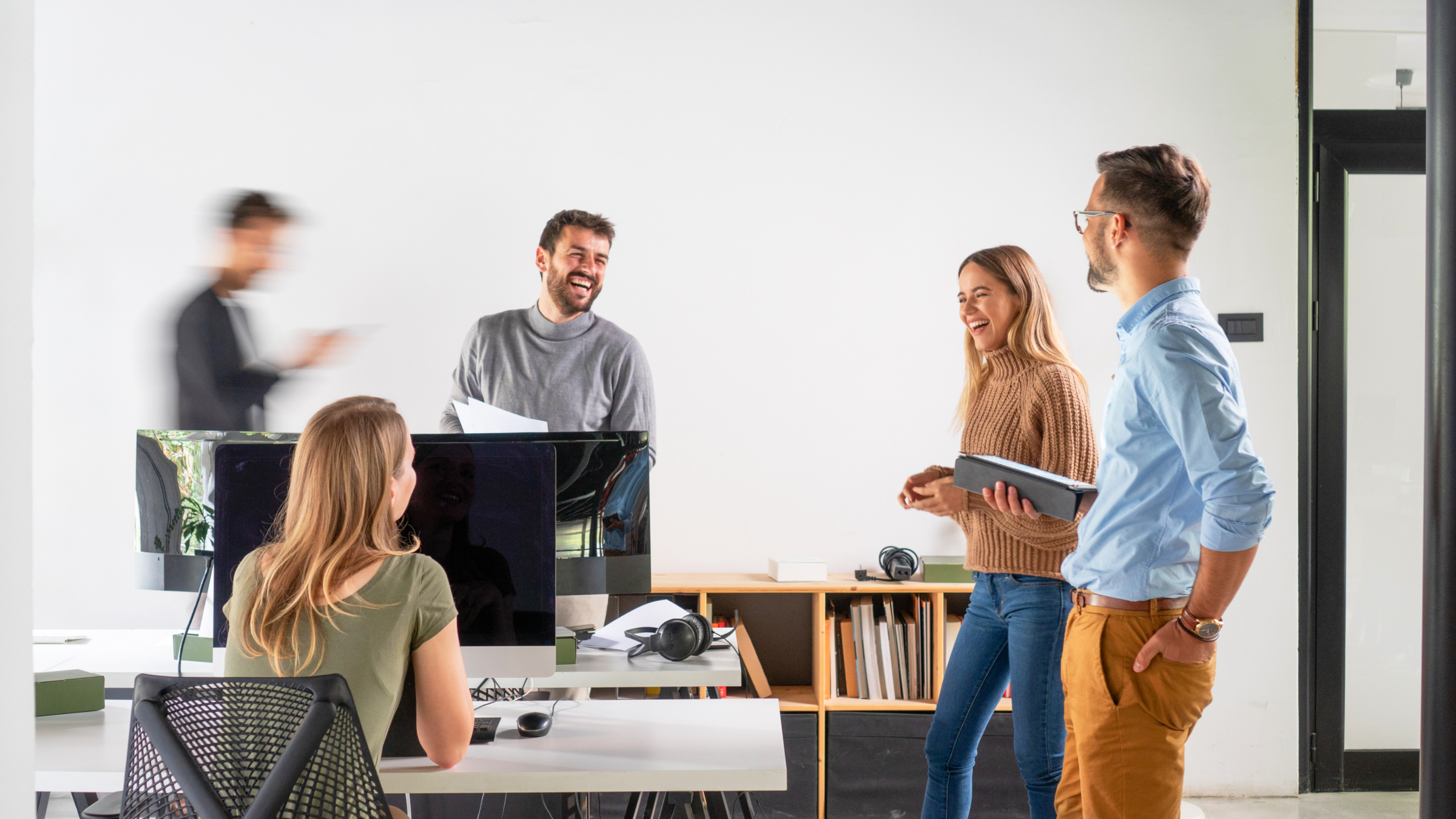 A group of employees talking to each other in an office.